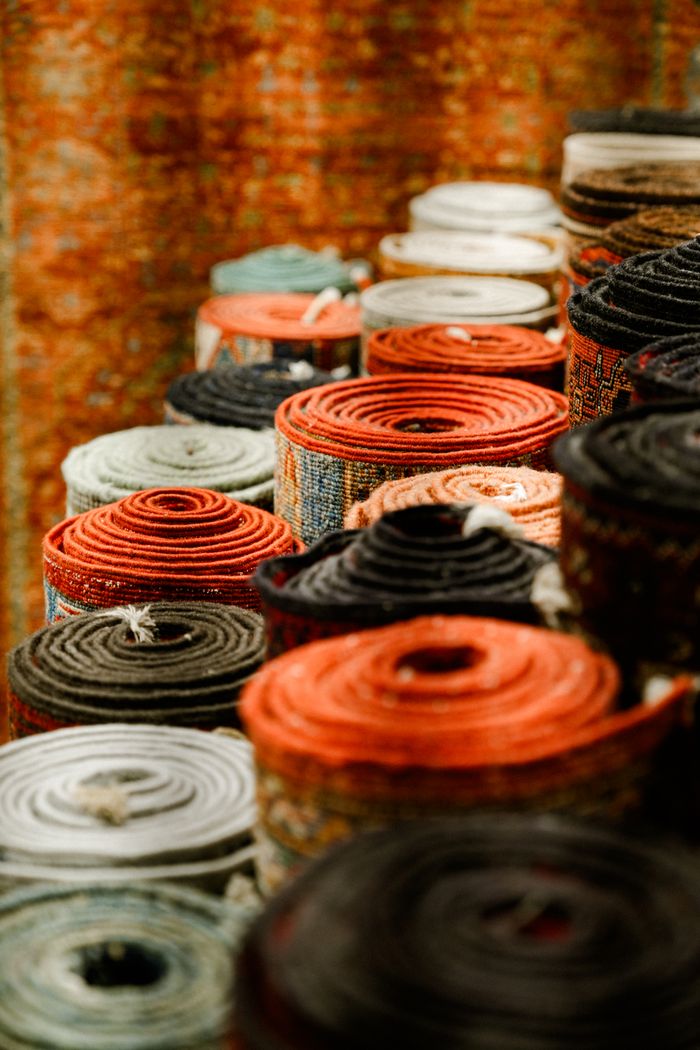 Vibrant rolled carpets showcasing diverse patterns in a market setting.